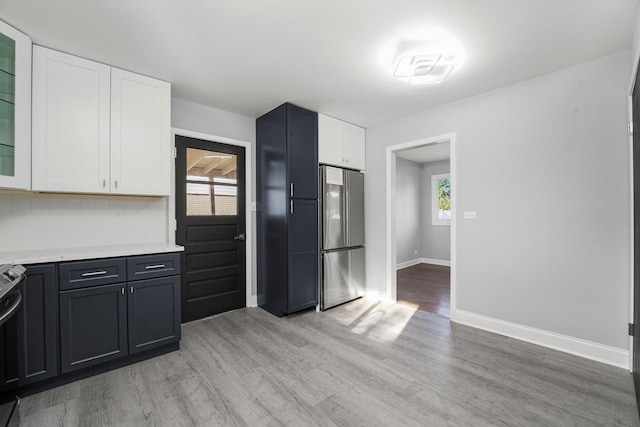 49 Stacy Ct, Glenview, IL 60025 - kitchen featuring freestanding refrigerator, light wood-style floors, white cabinetry, and light countertops