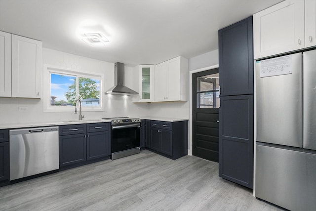 49 Stacy Ct, Glenview, IL 60025 - kitchen featuring appliances with stainless steel finishes, wall chimney range hood, white cabinets, light countertops, and light wood-style floors