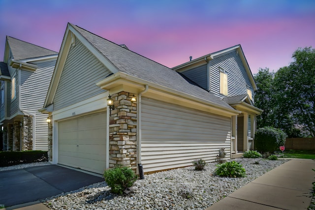 4576 Hilltop Dr, Loves Park, IL 61111 - view of side of property featuring a shingled roof, stone siding, driveway, and a garage