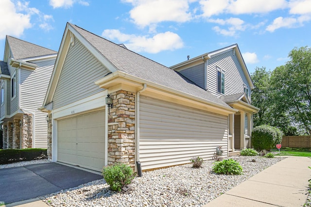4576 Hilltop Dr, Loves Park, IL 61111 - view of side of property with stone siding, a shingled roof, a garage, and driveway
