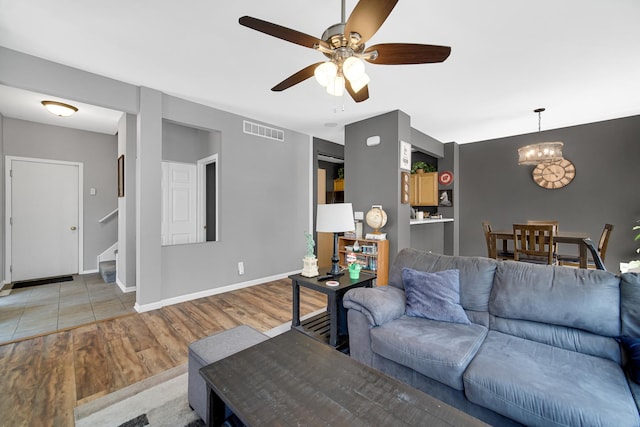 4576 Hilltop Dr, Loves Park, IL 61111 - living room featuring light wood-style floors, a ceiling fan, stairway, and a chandelier