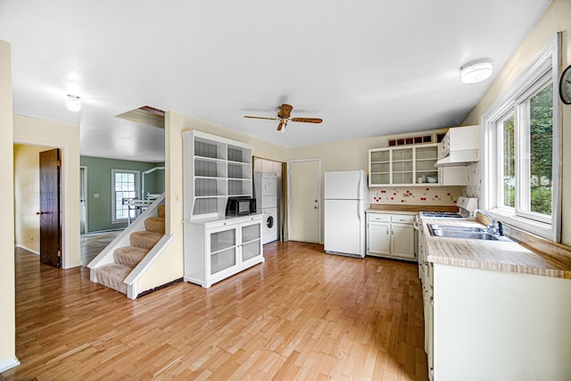 29W409 White Oak Dr, Warrenville, IL 60555 - kitchen featuring white appliances, stacked washing machine and dryer, light wood-style flooring, light countertops, and a ceiling fan
