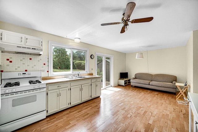29W409 White Oak Dr, Warrenville, IL 60555 - kitchen featuring white range with gas stovetop, under cabinet range hood, plenty of natural light, and light wood-style flooring