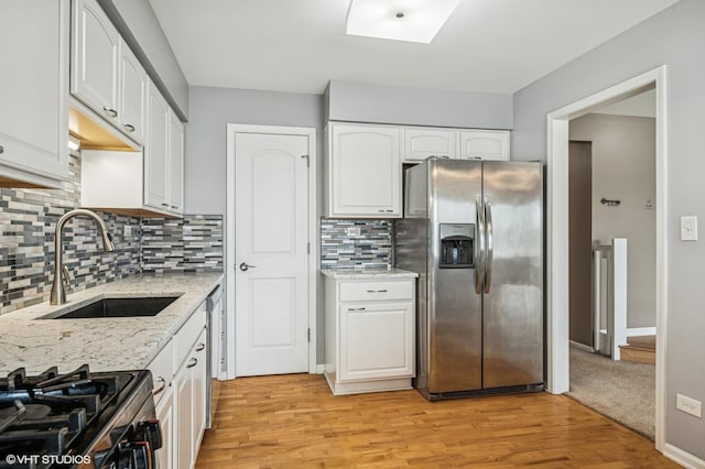 1234 Ballantrae Pl Unit D, Mundelein, IL 60060 - kitchen featuring stainless steel fridge, white cabinetry, light stone countertops, light wood-style floors, and decorative backsplash