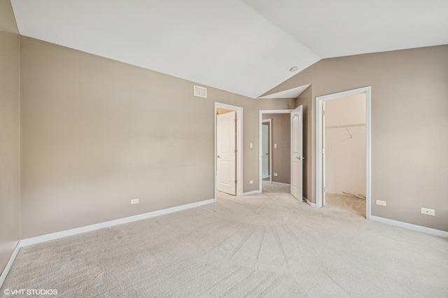 1234 Ballantrae Pl Unit D, Mundelein, IL 60060 - unfurnished bedroom with vaulted ceiling, a walk in closet, and light colored carpet