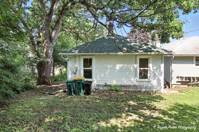 67 Wells St, Fox Lake, IL 60020 - rear view of house featuring a chimney, a shingled roof, and a yard