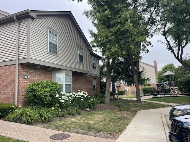 124 White Oak Ct Unit 2, Schaumburg, IL 60195 - view of property exterior featuring brick siding and a lawn