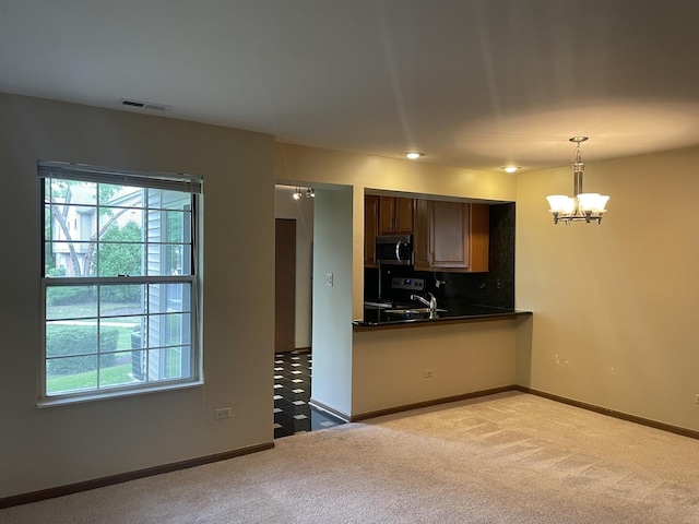124 White Oak Ct Unit 2, Schaumburg, IL 60195 - kitchen with dark countertops, stainless steel microwave, a chandelier, and healthy amount of natural light