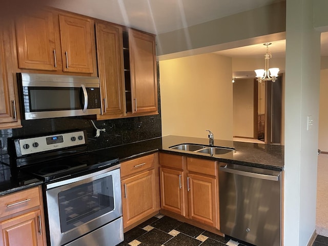 124 White Oak Ct Unit 2, Schaumburg, IL 60195 - kitchen featuring appliances with stainless steel finishes, decorative backsplash, dark countertops, a chandelier, and a peninsula