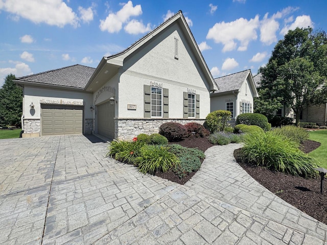 807 Wedgewood Ct, Lindenhurst, IL 60046 - view of front of house featuring a garage, stucco siding, decorative driveway, and stone siding