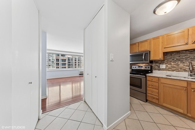 211 E Ohio St Unit 1825, Chicago, IL 60611 - kitchen with stainless steel appliances, light tile patterned floors, tasteful backsplash, and light stone counters