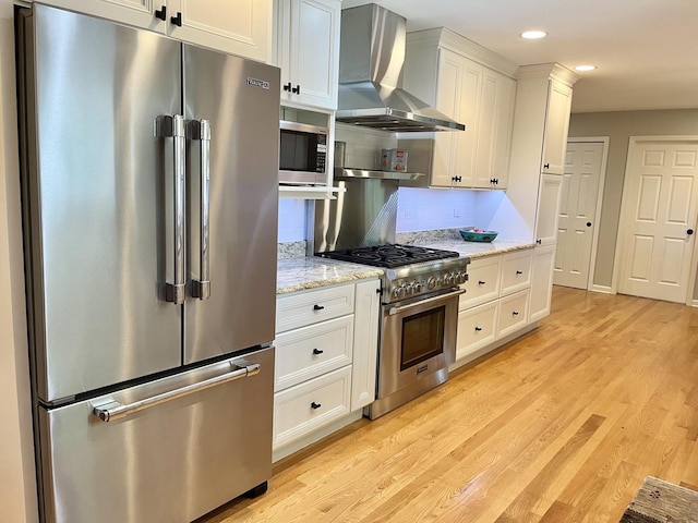 441 Highland Ave, Crystal Lake, IL 60014 - kitchen featuring high quality appliances, wall chimney exhaust hood, light wood-type flooring, recessed lighting, and white cabinetry