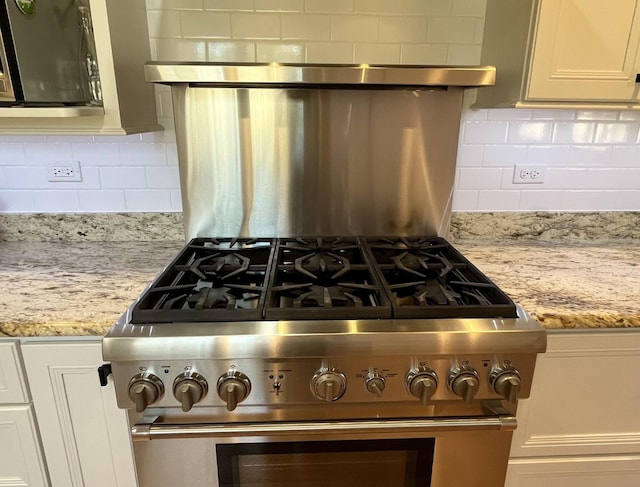 441 Highland Ave, Crystal Lake, IL 60014 - kitchen view of stainless steel stove, backsplash, range hood, and light stone counters