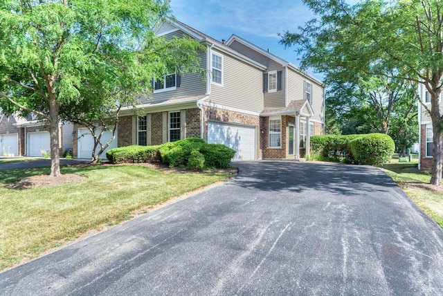 24341 Leski Ln, Plainfield, IL 60585 - traditional home featuring asphalt driveway, brick siding, an attached garage, and a front lawn