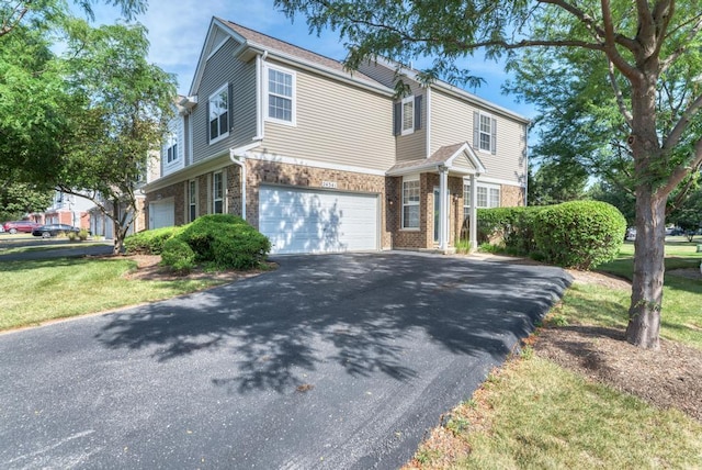 24341 Leski Ln, Plainfield, IL 60585 - traditional-style home featuring asphalt driveway, a garage, brick siding, and a front lawn
