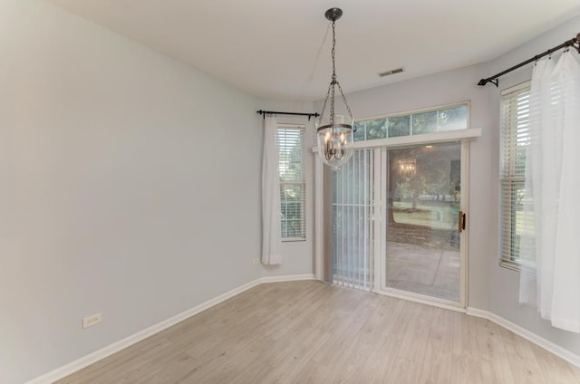 24341 Leski Ln, Plainfield, IL 60585 - unfurnished dining area featuring a chandelier, light wood-style floors, and plenty of natural light
