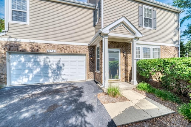 24341 Leski Ln, Plainfield, IL 60585 - view of front of house featuring brick siding, a garage, and driveway