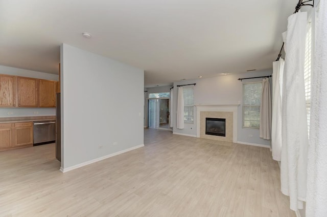 24341 Leski Ln, Plainfield, IL 60585 - unfurnished living room with light wood finished floors and a glass covered fireplace