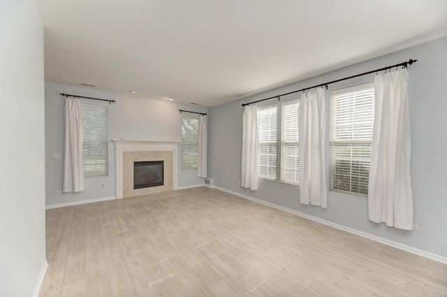 24341 Leski Ln, Plainfield, IL 60585 - unfurnished living room featuring light wood finished floors and a glass covered fireplace