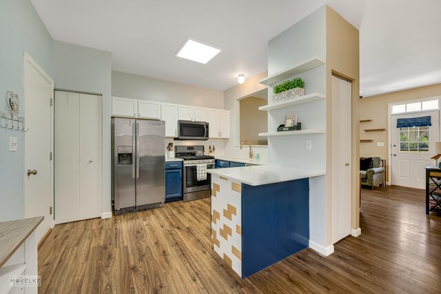 2326 Woodhill Ct, Plainfield, IL 60586 - kitchen with appliances with stainless steel finishes, open shelves, blue cabinetry, wood finished floors, and light countertops