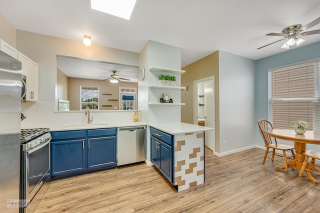 2326 Woodhill Ct, Plainfield, IL 60586 - kitchen with stainless steel appliances, blue cabinets, a ceiling fan, a peninsula, and light wood finished floors