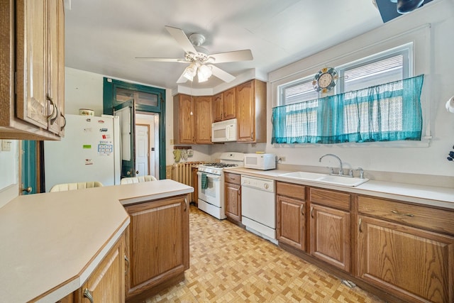 2955 N Lotus Ave, Chicago, IL 60641 - kitchen with white appliances, light flooring, light countertops, a ceiling fan, and brown cabinets