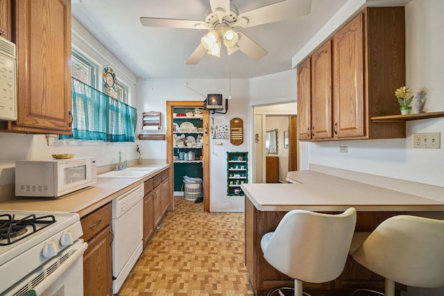 2955 N Lotus Ave, Chicago, IL 60641 - kitchen with white appliances, light countertops, brown cabinetry, and a ceiling fan