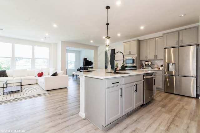 24518 W Alexis Ln, Plainfield, IL 60585 - kitchen with gray cabinets, stainless steel appliances, open floor plan, light wood-style floors, and light countertops