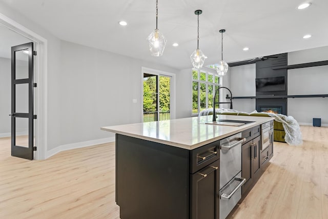 25216 S Channault Ave, Monee, IL 60449 - kitchen featuring light wood finished floors, recessed lighting, a large fireplace, an island with sink, and pendant lighting