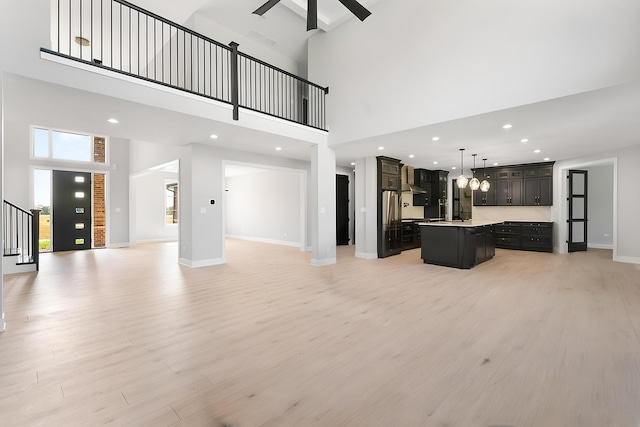 25216 S Channault Ave, Monee, IL 60449 - unfurnished living room with a towering ceiling, light wood-style floors, stairs, ceiling fan, and recessed lighting