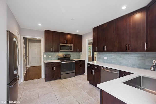 2543 Crawford Ave, Evanston, IL 60201 - kitchen with stainless steel appliances, light countertops, backsplash, light tile patterned floors, and recessed lighting
