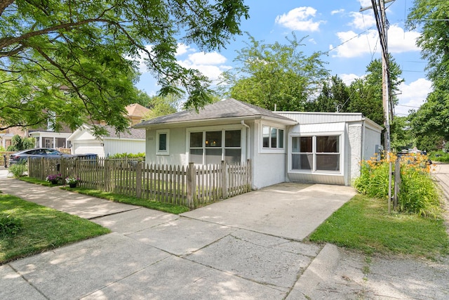 2222 Grey Ave, Evanston, IL 60201 - bungalow-style home featuring a fenced front yard, concrete driveway, and stucco siding