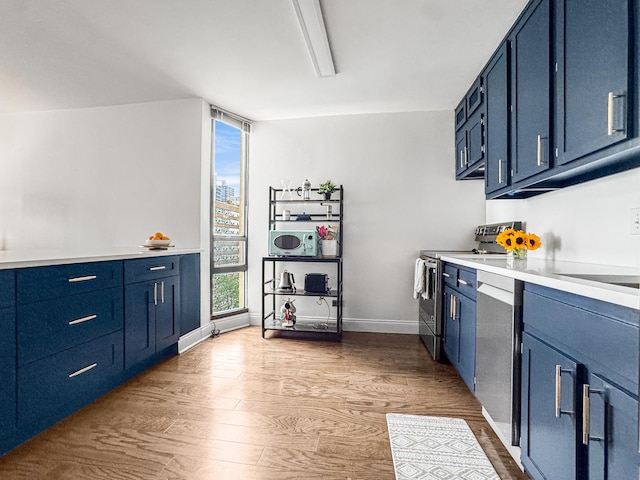 3150 N Sheridan Rd Unit 10C, Chicago, IL 60657 - kitchen with stainless steel appliances, blue cabinetry, and wood finished floors