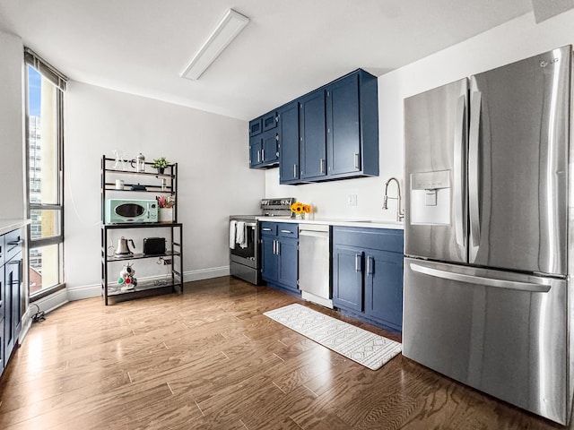 3150 N Sheridan Rd Unit 10C, Chicago, IL 60657 - kitchen featuring appliances with stainless steel finishes, blue cabinetry, healthy amount of natural light, and light countertops