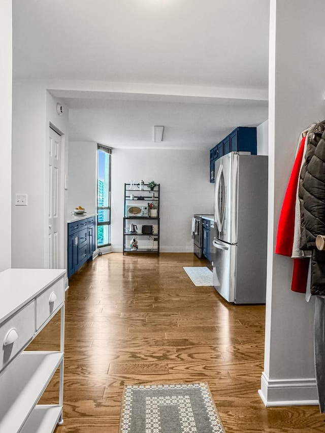 3150 N Sheridan Rd Unit 10C, Chicago, IL 60657 - kitchen with blue cabinets, appliances with stainless steel finishes, wood finished floors, and light countertops