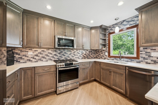2430 Lakeside Dr, Aurora, IL 60504 - kitchen featuring appliances with stainless steel finishes, light countertops, open shelves, light wood finished floors, and decorative backsplash