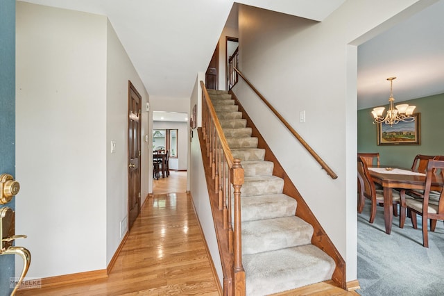 2430 Lakeside Dr, Aurora, IL 60504 - staircase featuring a chandelier and wood finished floors