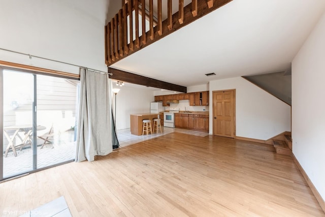 3341 Beacon St Unit 32, North Chicago, IL 60064 - unfurnished living room with light wood finished floors and beam ceiling