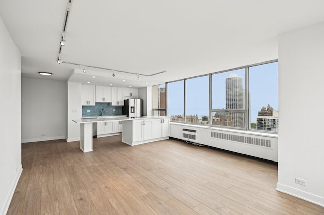 70 W Burton Pl Unit 2505F, Chicago, IL 60610 - kitchen with stainless steel fridge, rail lighting, light countertops, white cabinets, and light wood-style flooring