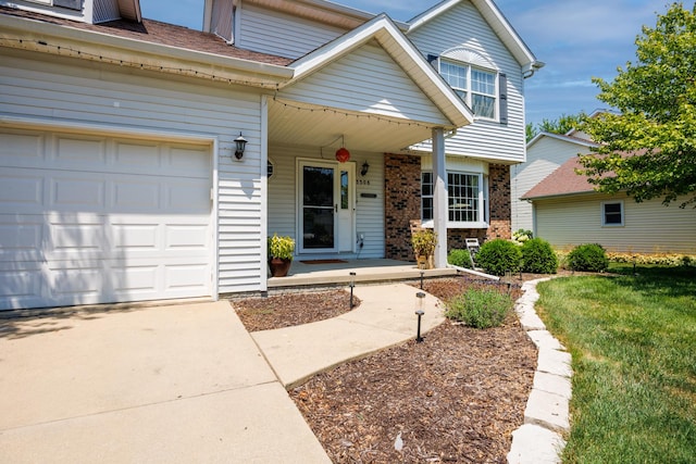 3308 Cumbria Dr, Bloomington, IL 61704 - view of front of property with covered porch, brick siding, an attached garage, driveway, and a front lawn