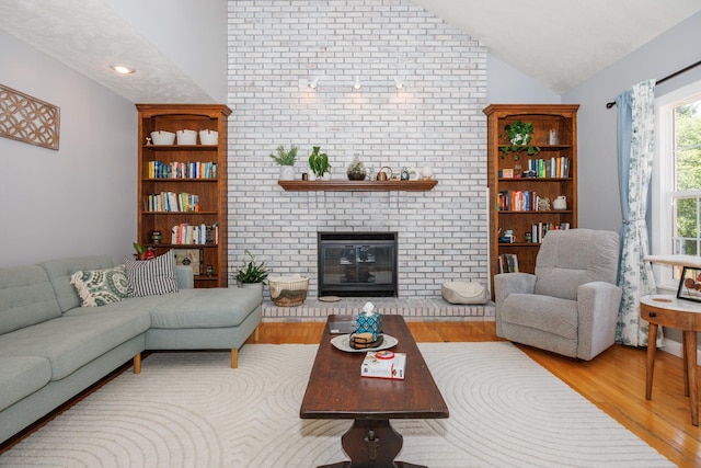 3308 Cumbria Dr, Bloomington, IL 61704 - living area featuring wood finished floors, vaulted ceiling, and a fireplace