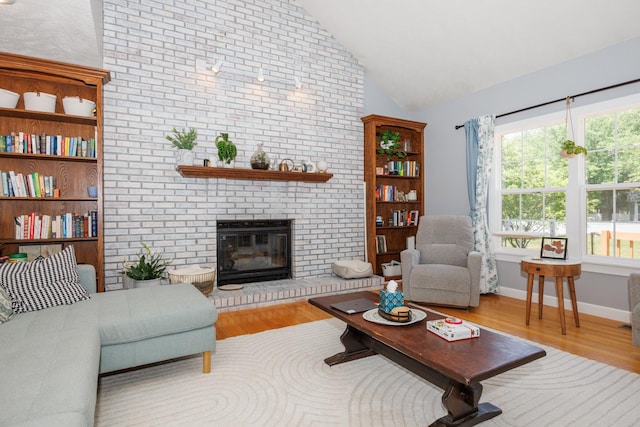 3308 Cumbria Dr, Bloomington, IL 61704 - living area with lofted ceiling, wood finished floors, and a fireplace