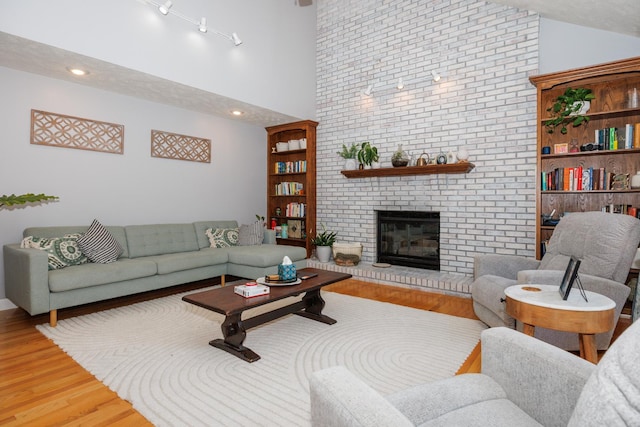 3308 Cumbria Dr, Bloomington, IL 61704 - living area with light wood-style floors, a fireplace, and high vaulted ceiling