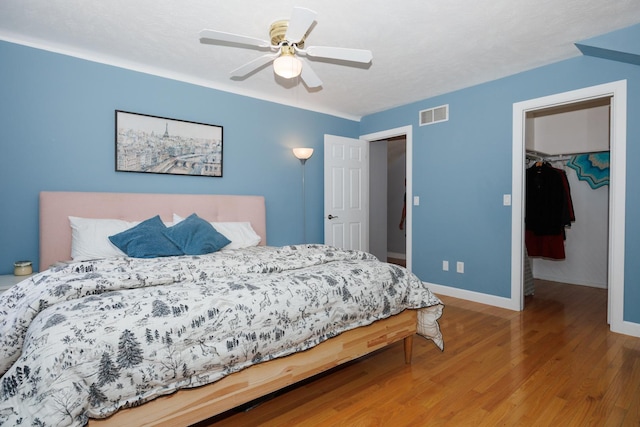 3308 Cumbria Dr, Bloomington, IL 61704 - bedroom with a spacious closet, wood finished floors, and a ceiling fan