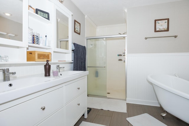 3308 Cumbria Dr, Bloomington, IL 61704 - full bathroom featuring a stall shower, double vanity, a soaking tub, wainscoting, and wood finished floors