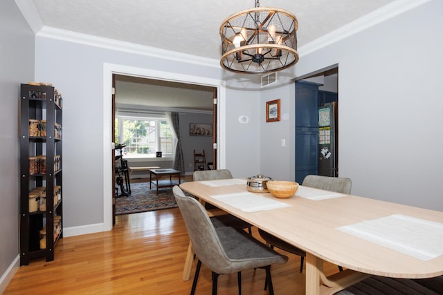 3308 Cumbria Dr, Bloomington, IL 61704 - dining room featuring light wood-style floors, a chandelier, and crown molding