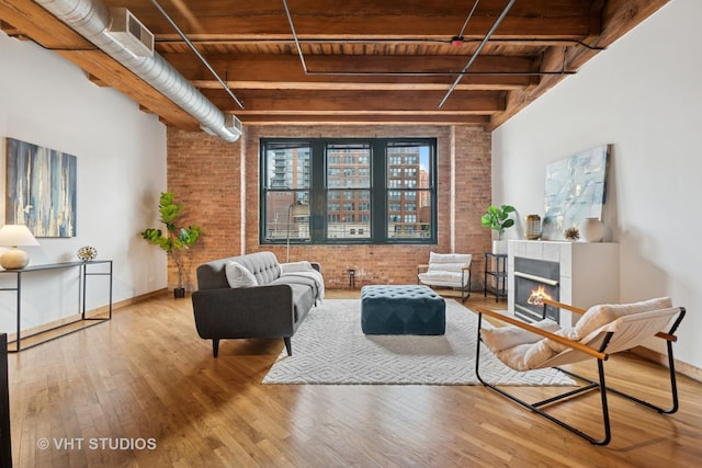 732 S Financial Pl Unit 202, Chicago, IL 60605 - living area with brick wall, a wood ceiling with exposed beams, wood finished floors, and a tiled fireplace