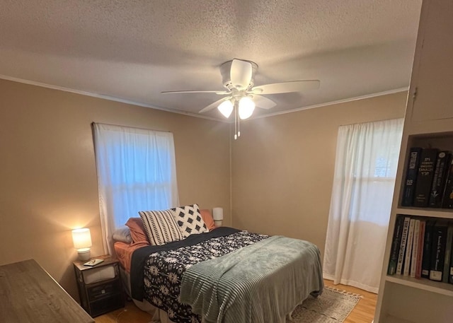 1302 Briarcliff Dr, Urbana, IL 61801 - bedroom featuring crown molding, light wood finished floors, a textured ceiling, and a ceiling fan
