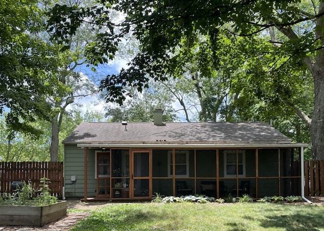 1302 Briarcliff Dr, Urbana, IL 61801 - rear view of house featuring a sunroom, a vegetable garden, roof with shingles, and a chimney