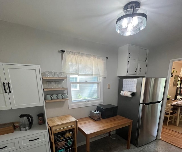 1302 Briarcliff Dr, Urbana, IL 61801 - kitchen featuring freestanding refrigerator, light countertops, light tile patterned flooring, and white cabinetry